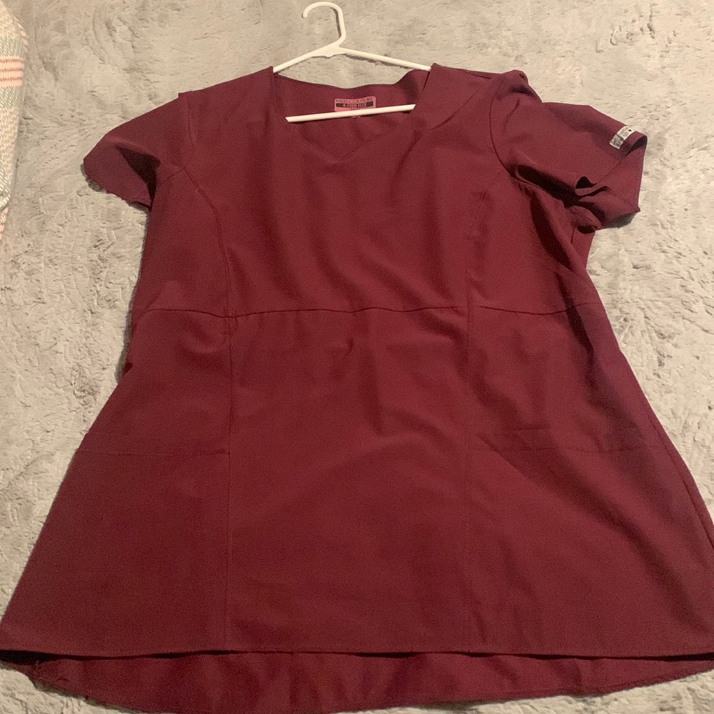 Burgundy women’s scrub shirt, size 2X the brand is Med Couture 4-Ever Flex.